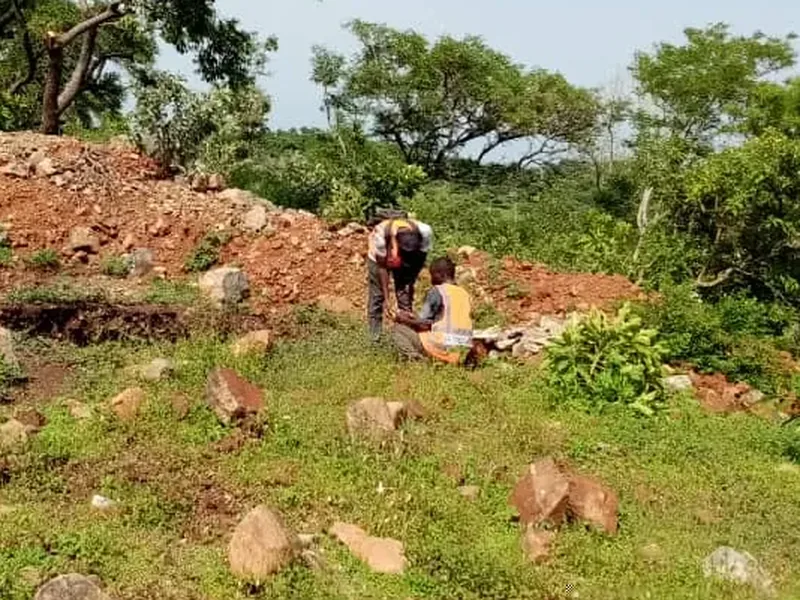 Geologist examining rock at the edge of a trench