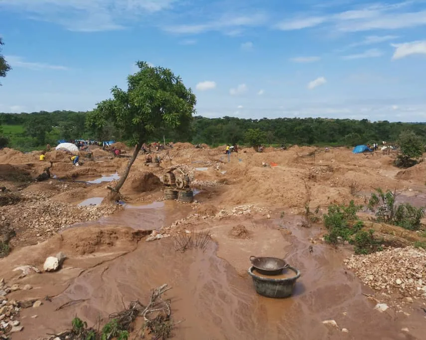 Mining site with excavated pits, washing ponds and stockpiled ore