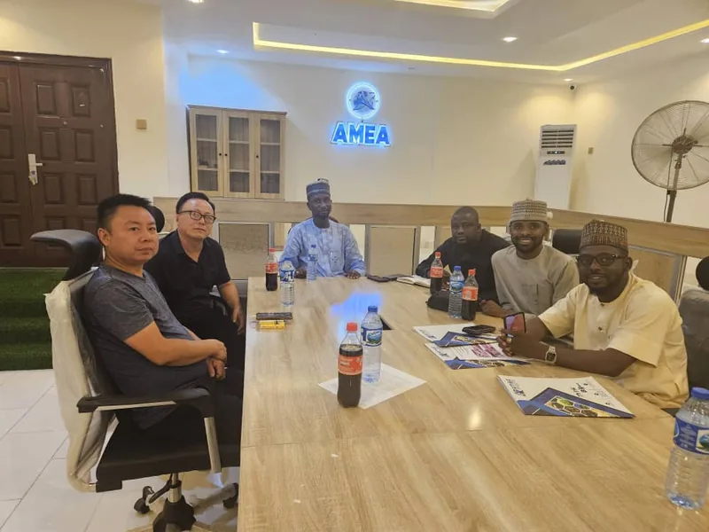 AMEA team and visiting partners at the boardroom table beneath the AMEA sign