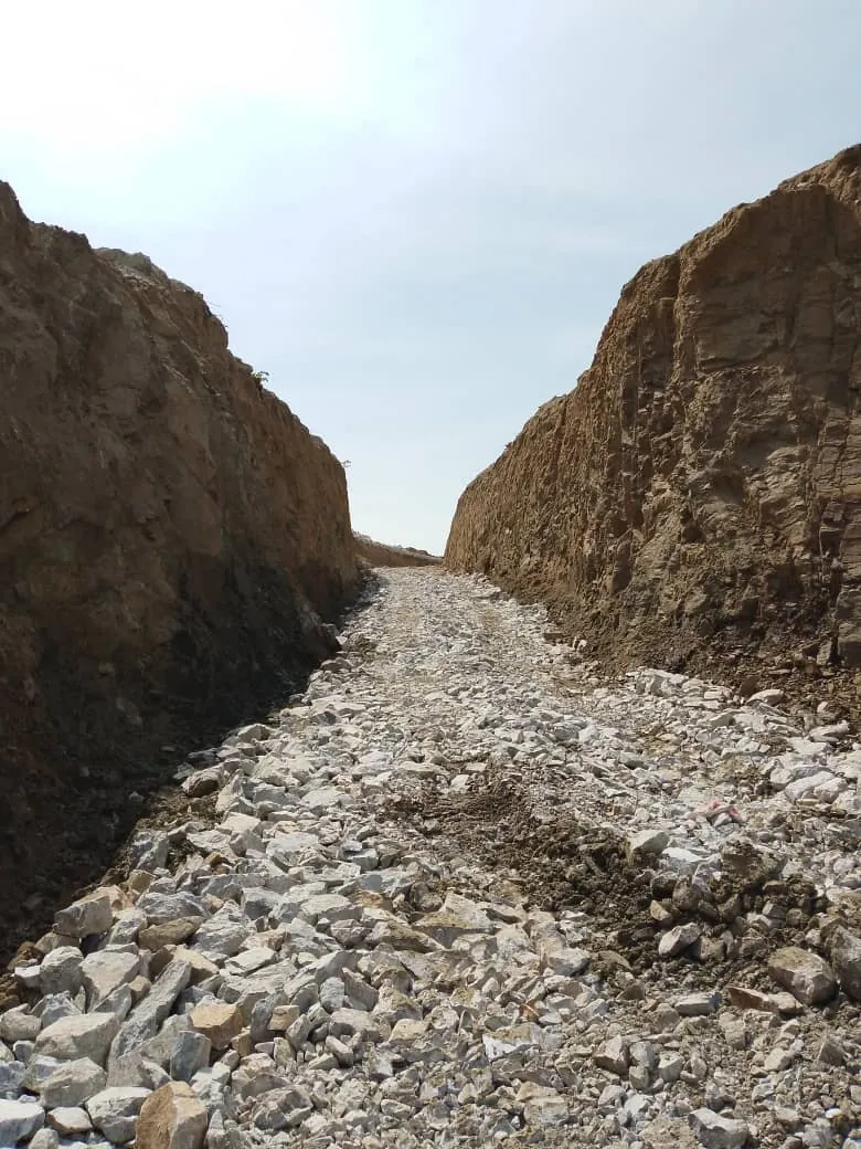Long cut opened through the hillside, floored with broken rock